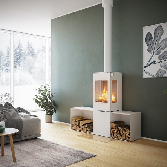 Holz-Kaminofen NEXO 120 in Weiss mit Stahltür, zwei Seitenfenstern und zwei Seitenbänken vor grüner Wand in dekorativem Wohnraum